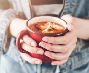 Women holding soup in a cup