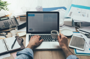 Man working at a messy desk how to improve productivity in the workplace