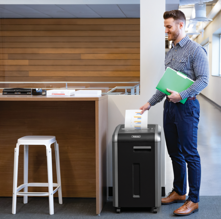 A guy shredding paper in fellowes 225Ci shredder